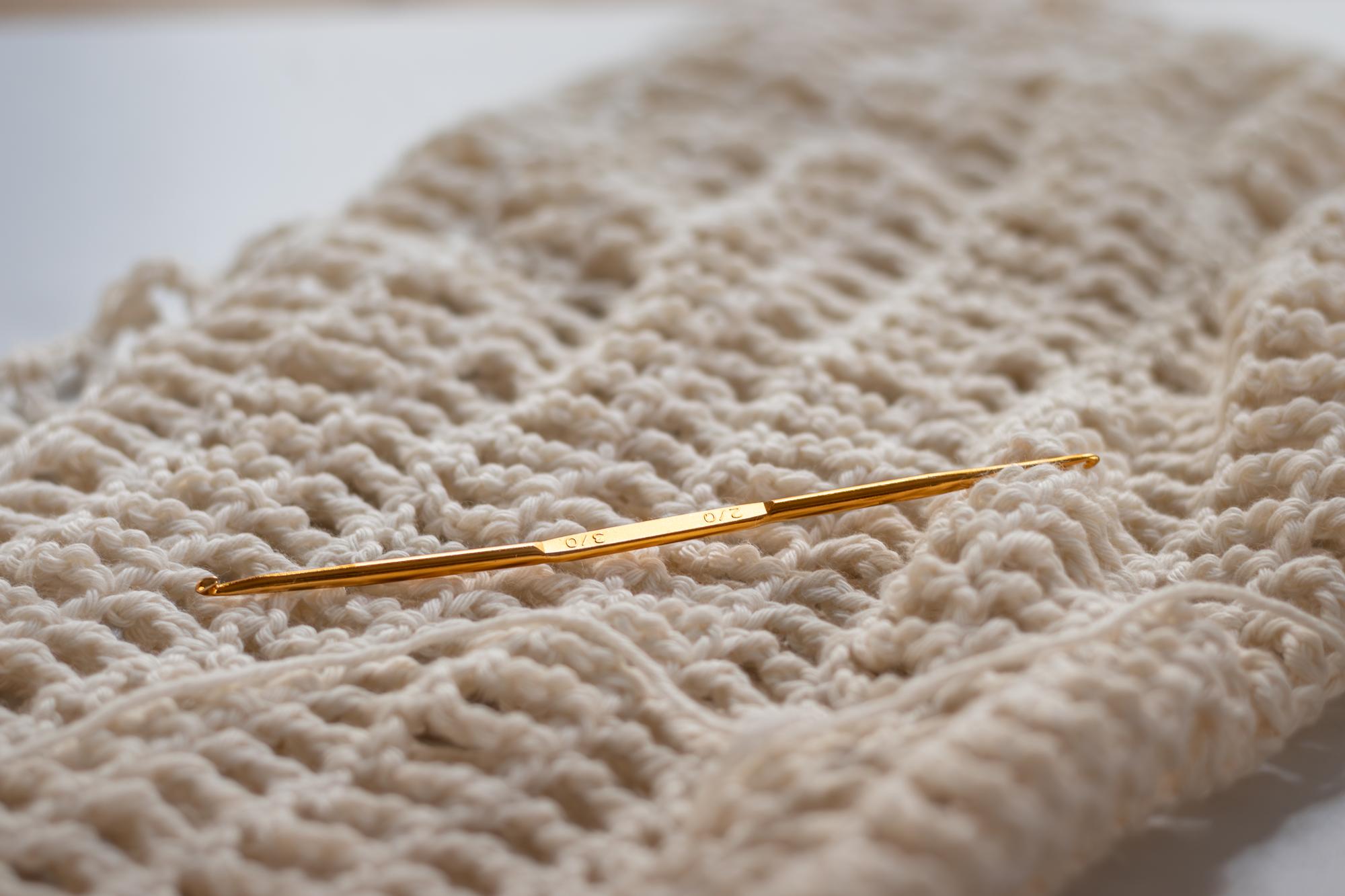 Close-up of hand embroidery on linen with golden thread